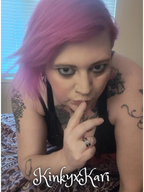 Cam model KinkyxKari KariGrant holding a finger to her lips as if to quiet you so she can do naughty things to you.